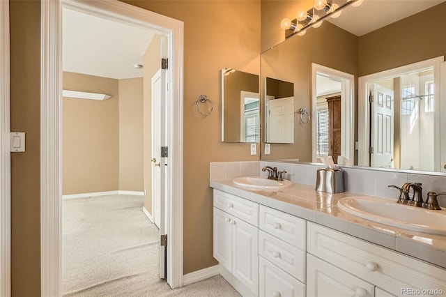 full bathroom featuring a sink, baseboards, and double vanity