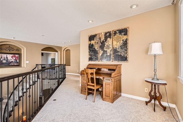 carpeted office space with recessed lighting, baseboards, and arched walkways