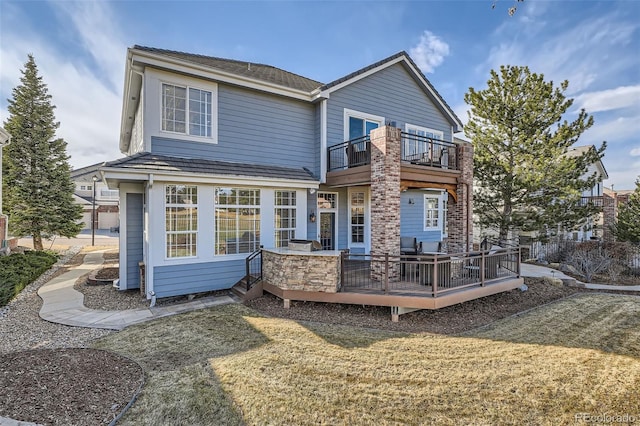 back of property with a balcony and a lawn