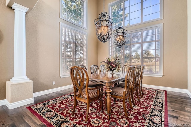 dining area with decorative columns, baseboards, and dark wood-style flooring