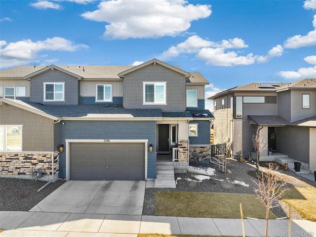 view of front of property featuring stone siding, concrete driveway, and a residential view