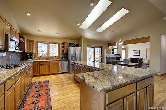 kitchen with a wealth of natural light, light wood-style flooring, stainless steel appliances, and open shelves