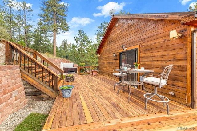 wooden terrace featuring stairs and outdoor dining space