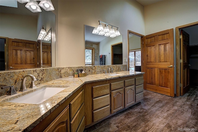 full bathroom with a sink, decorative backsplash, a high ceiling, and wood finished floors