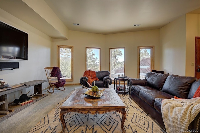 living room featuring visible vents, baseboards, and light colored carpet