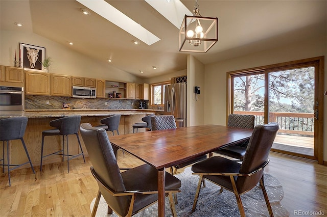 dining room with a skylight, light wood-type flooring, and a wealth of natural light