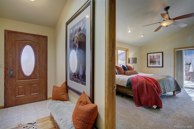 foyer with vaulted ceiling, plenty of natural light, light tile patterned floors, and ceiling fan