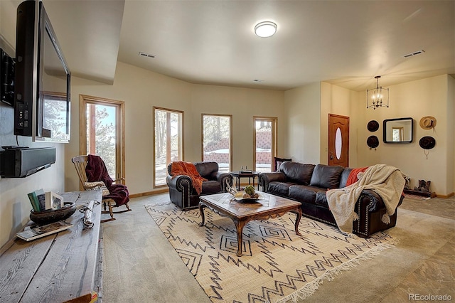 living area with light carpet, visible vents, an inviting chandelier, and baseboards