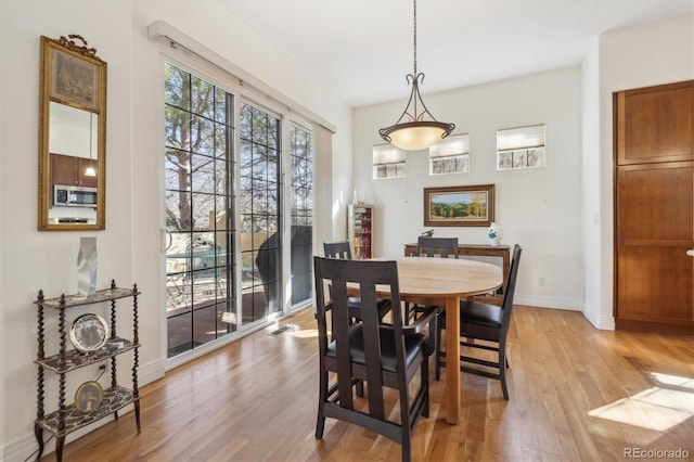 dining room with baseboards and light wood-style floors