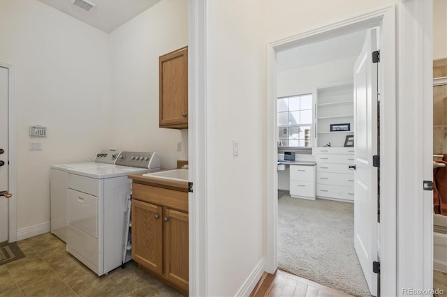 laundry room with visible vents, cabinet space, separate washer and dryer, and light carpet