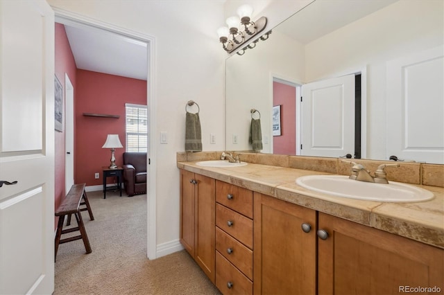 bathroom with double vanity, baseboards, and a sink