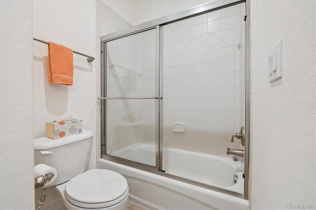 bathroom with toilet and bath / shower combo with glass door