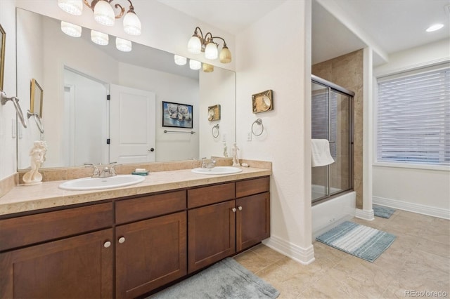 bathroom with double vanity, tile patterned floors, shower / bath combination with glass door, and a sink