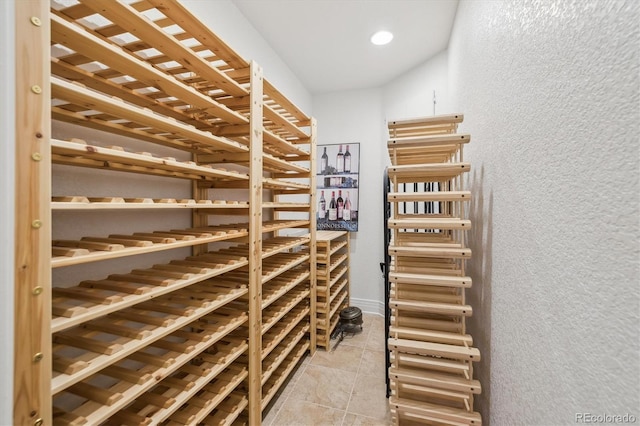 wine area with light tile patterned flooring, a textured wall, and recessed lighting