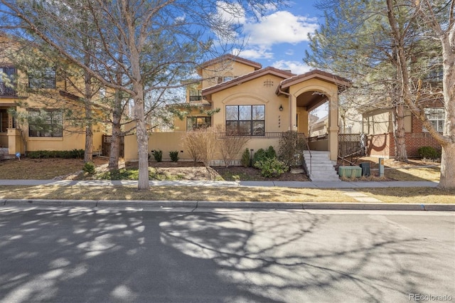 view of front of home featuring stucco siding and a tile roof