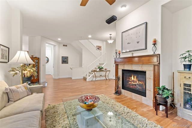 7444 E 9th Ave, Denver, CO 80230 - living area with a tiled fireplace, wood finished floors, ceiling fan, stairs, and recessed lighting