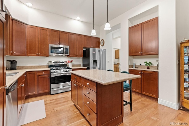7444 E 9th Ave, Denver, CO 80230 - kitchen with stainless steel appliances, light wood-style floors, a kitchen bar, light countertops, and recessed lighting