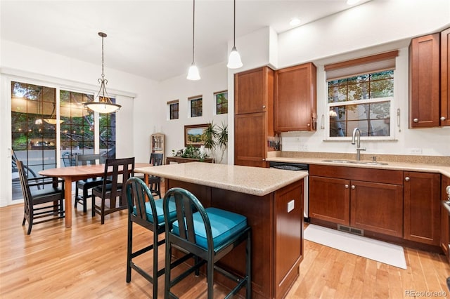 7444 E 9th Ave, Denver, CO 80230 - kitchen featuring a sink, light wood finished floors, a center island, stainless steel dishwasher, and pendant lighting