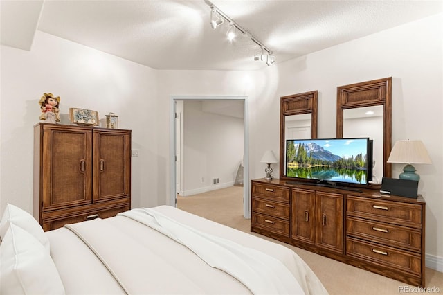 7444 E 9th Ave, Denver, CO 80230 - bedroom featuring track lighting, light colored carpet, baseboards, and a textured ceiling