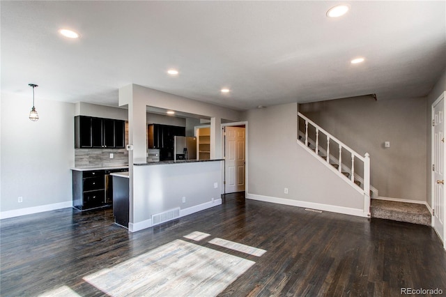 kitchen with decorative light fixtures, dark wood-type flooring, decorative backsplash, and stainless steel fridge with ice dispenser