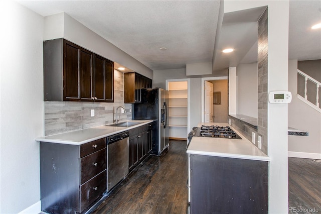 kitchen featuring dark hardwood / wood-style flooring, stainless steel appliances, sink, backsplash, and dark brown cabinets