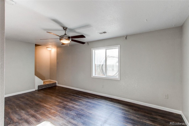 spare room with ceiling fan, a textured ceiling, and dark hardwood / wood-style floors