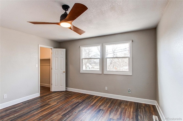 empty room featuring dark wood-type flooring and ceiling fan