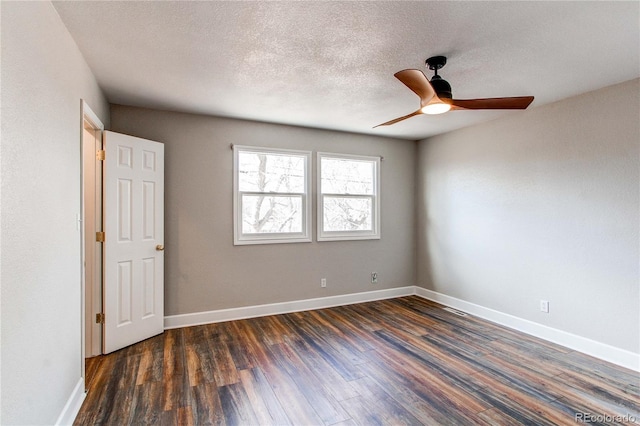 empty room with ceiling fan, dark hardwood / wood-style flooring, and a textured ceiling