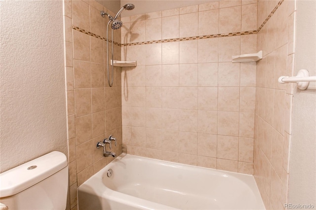 bathroom featuring toilet and tiled shower / bath