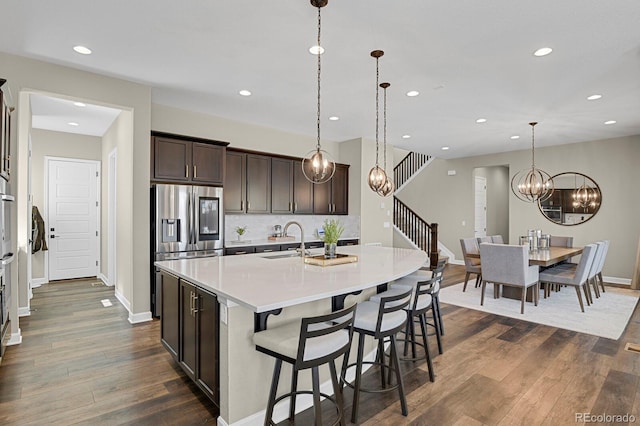 kitchen featuring dark wood-style floors, light countertops, dark brown cabinetry, and a sink