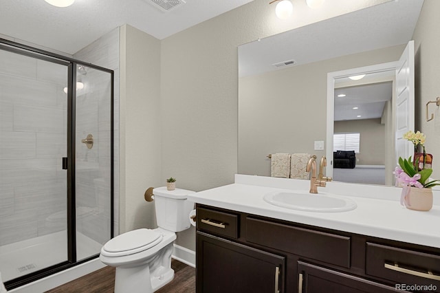 full bathroom featuring visible vents, toilet, wood finished floors, vanity, and a shower stall