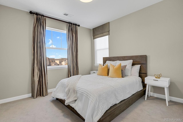 bedroom featuring baseboards, visible vents, and light colored carpet