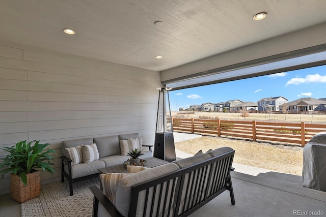 view of patio featuring outdoor lounge area, fence, and a residential view