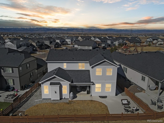 view of front of property with a shingled roof, a residential view, fence, and a patio