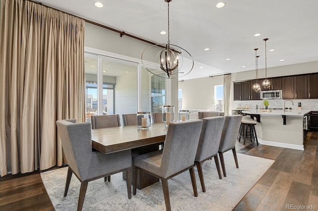 dining space with recessed lighting, dark wood finished floors, and an inviting chandelier