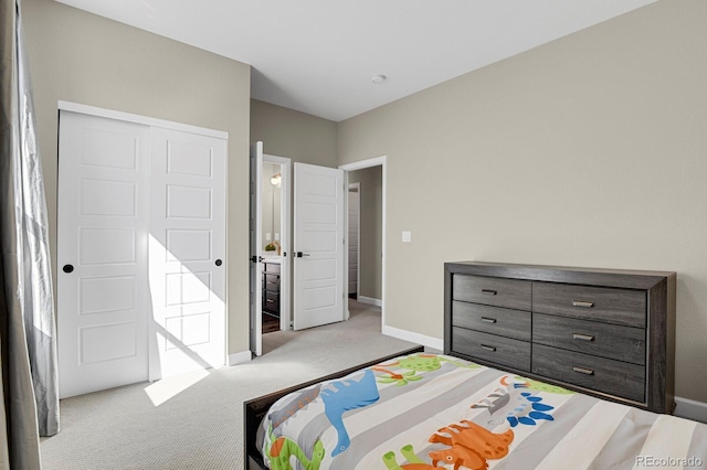 carpeted bedroom with a closet and baseboards