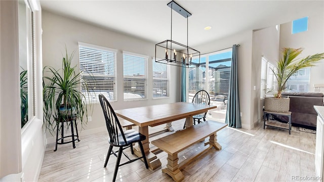 dining area featuring light wood finished floors, plenty of natural light, and a chandelier