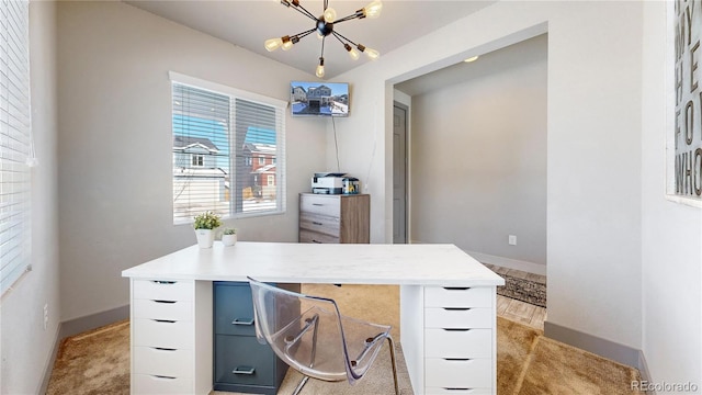 office space featuring light carpet, an inviting chandelier, and baseboards