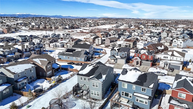 snowy aerial view featuring a residential view and a mountain view