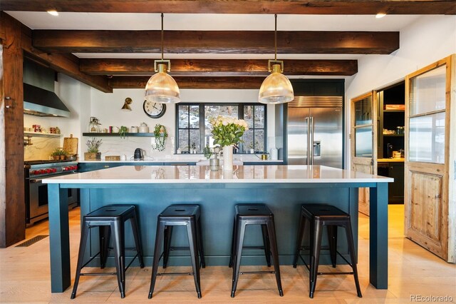 534 W Meadow Rd, Evergreen, CO 80439 - kitchen with high end appliances, beamed ceiling, light countertops, light wood finished floors, and open shelves