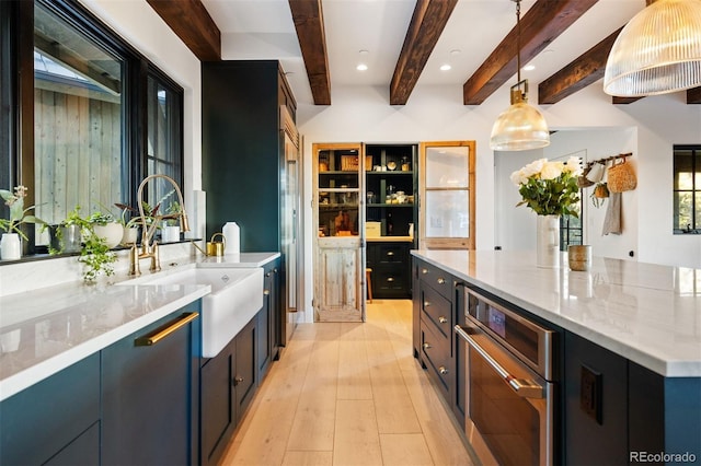 534 W Meadow Rd, Evergreen, CO 80439 - kitchen featuring beam ceiling, light stone counters, decorative light fixtures, a spacious island, and light wood-type flooring