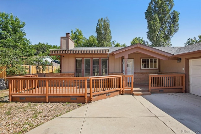 215 Sunland St, Louisville, CO 80027 - view of front of property featuring a chimney, driveway, a garage, a wooden deck, and crawl space