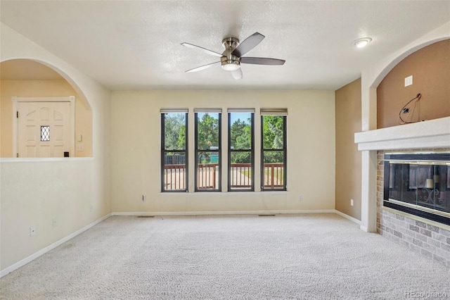 215 Sunland St, Louisville, CO 80027 - unfurnished living room featuring ceiling fan, carpet flooring, a glass covered fireplace, and a textured ceiling