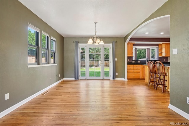 215 Sunland St, Louisville, CO 80027 - dining space with a chandelier, light wood finished floors, plenty of natural light, arched walkways, and recessed lighting