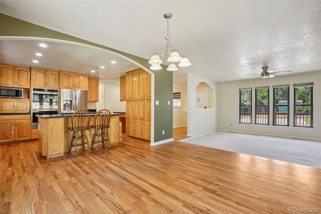 215 Sunland St, Louisville, CO 80027 - kitchen featuring appliances with stainless steel finishes, recessed lighting, a kitchen island, dark countertops, and light wood finished floors