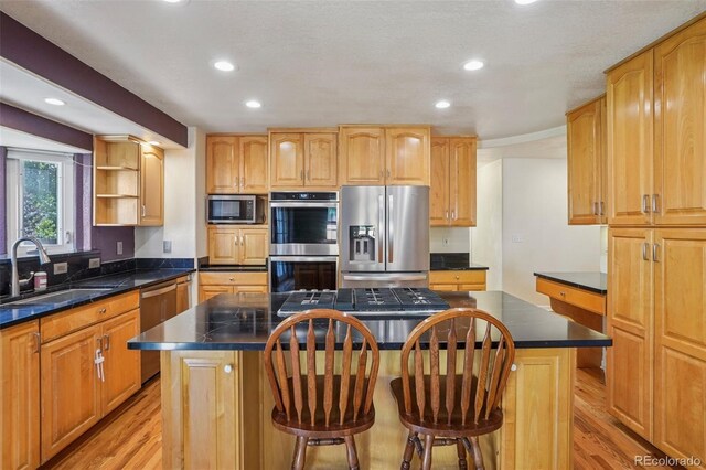 215 Sunland St, Louisville, CO 80027 - kitchen featuring appliances with stainless steel finishes, a center island, light wood-style floors, dark countertops, and recessed lighting