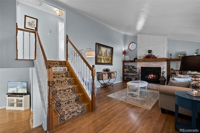 living room featuring ornamental molding, vaulted ceiling, and hardwood / wood-style floors