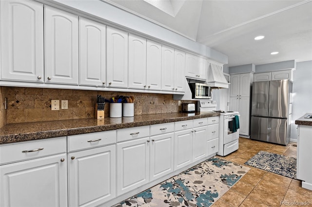 kitchen with custom range hood, light tile patterned flooring, white cabinetry, appliances with stainless steel finishes, and tasteful backsplash