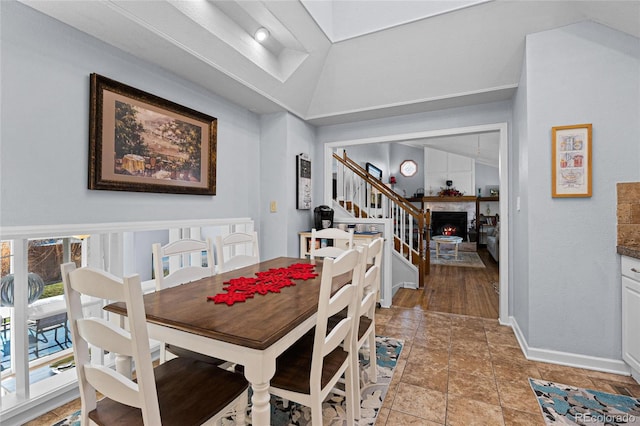 dining space featuring wood-type flooring and lofted ceiling