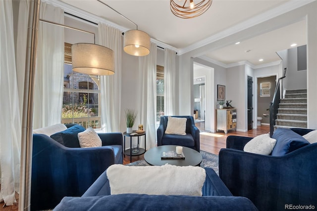 living room featuring hardwood / wood-style flooring, ornamental molding, and a wealth of natural light